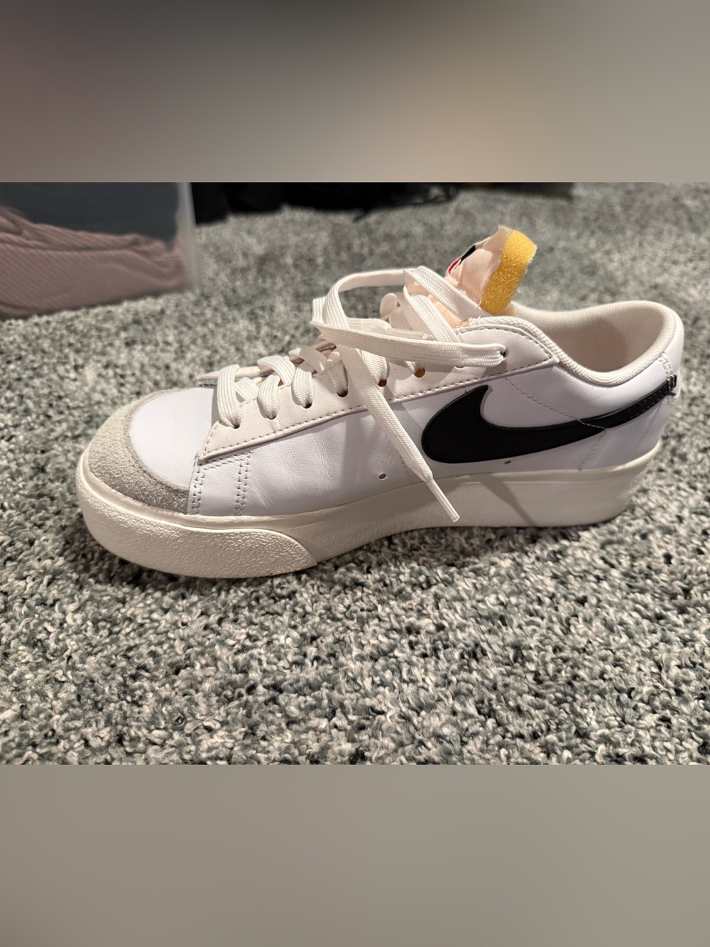 Nike White Low-Top Sneaker with Black Swoosh and Yellow Heel Tab